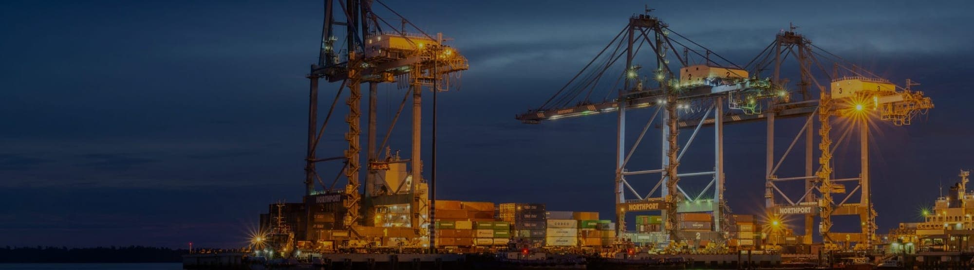 Container cranes at a Batam port at dusk